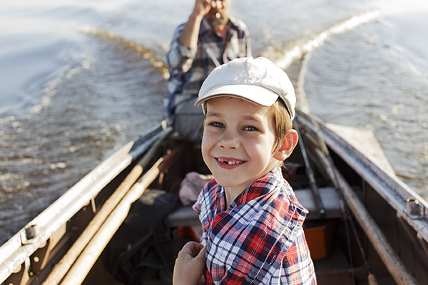 Caucasian boy smiling at camera while in a boat